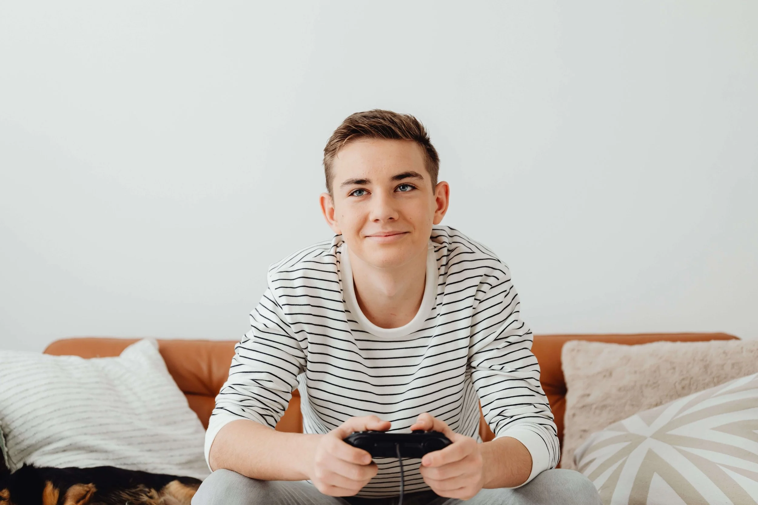A teen boy sits on a couch holding a video game controller. Is your teen boy using gaming or other escapes to cope with emotions he hasn't learned how to talk through yet? A teen therapist in San Ramon, CA, can help him build lasting skills.