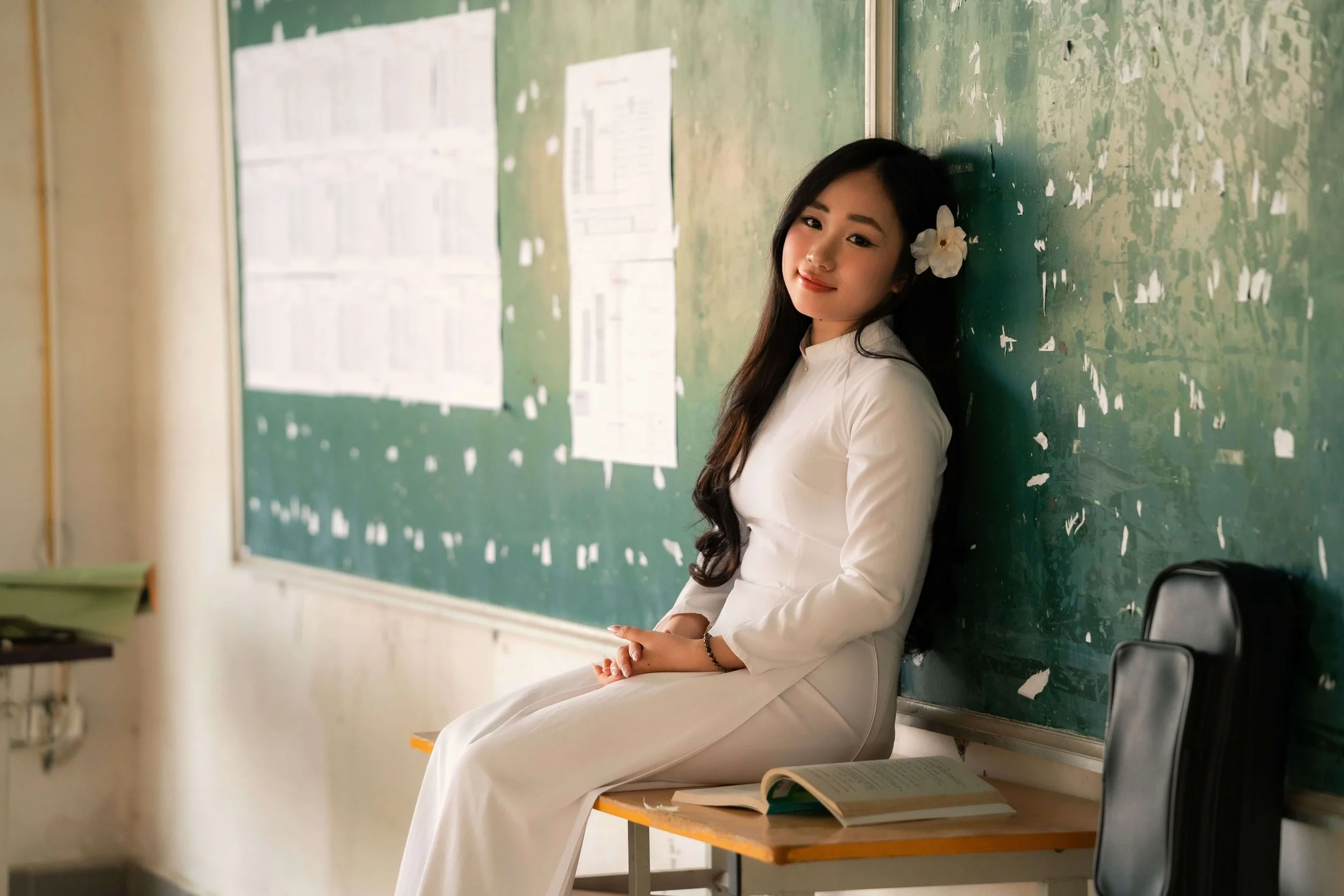 A teen girl sits on a classroom desk, leaning back against an old chalkboard. What makes starting high school feel so overwhelming for teens? Teen therapy in San Ramon, CA can help ease this challenging transition.