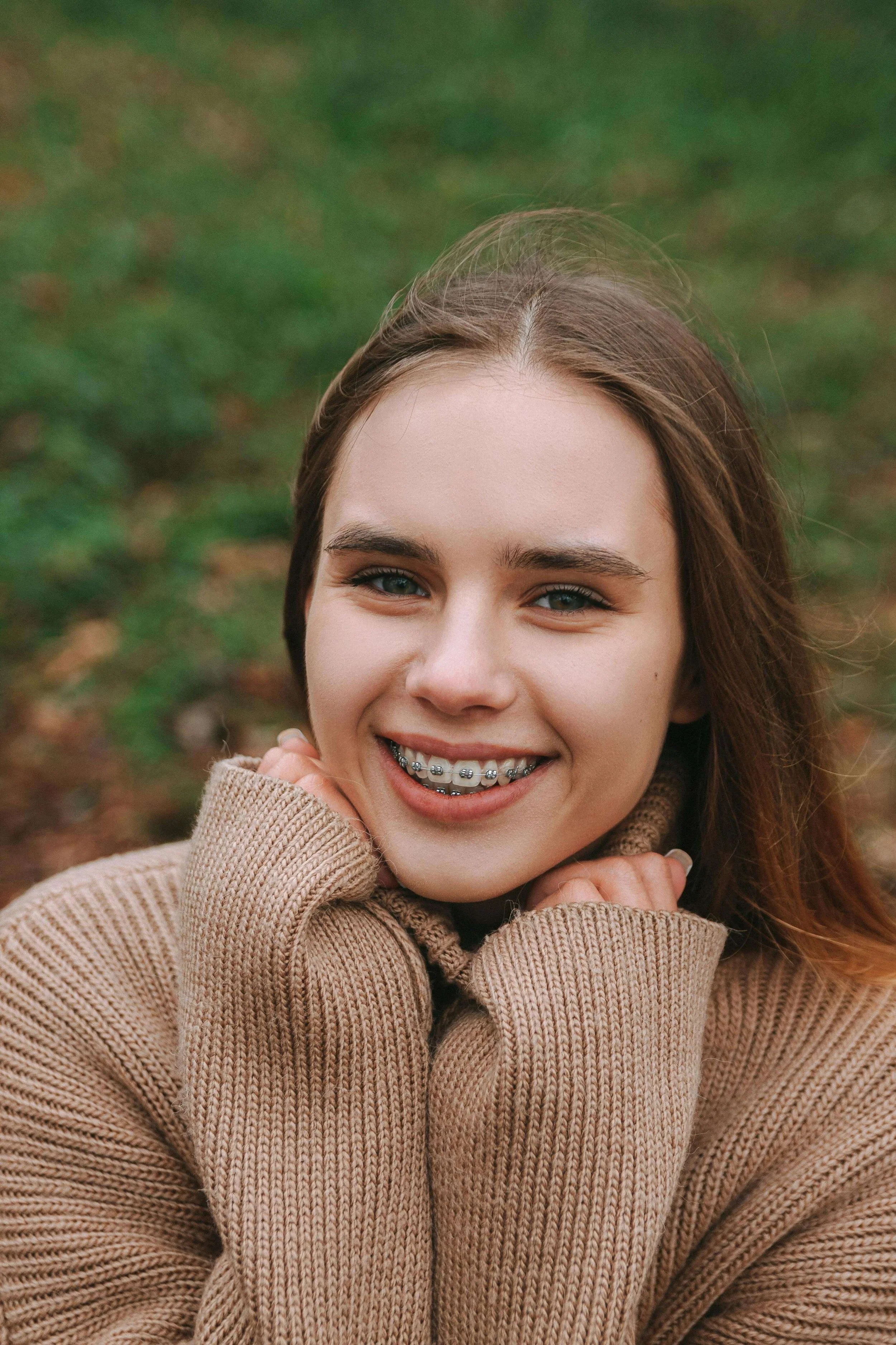 A happy teen with braces smiles while outside. Do you want to help your teen break through perfectionism? Teen therapy in San Ramon, CA, can help them let go of unrealistic standards and expectations.