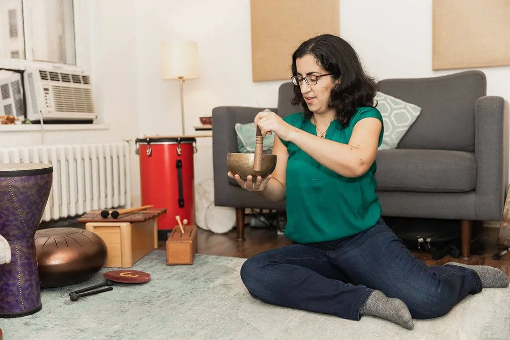 NYC anxiety therapist Maya plays a Tibetan singing bowl in her Midtown Manhattan therapy office. Women with anxiety in New York City can get therapy here! Try online therapy in New York for anxiety help too!