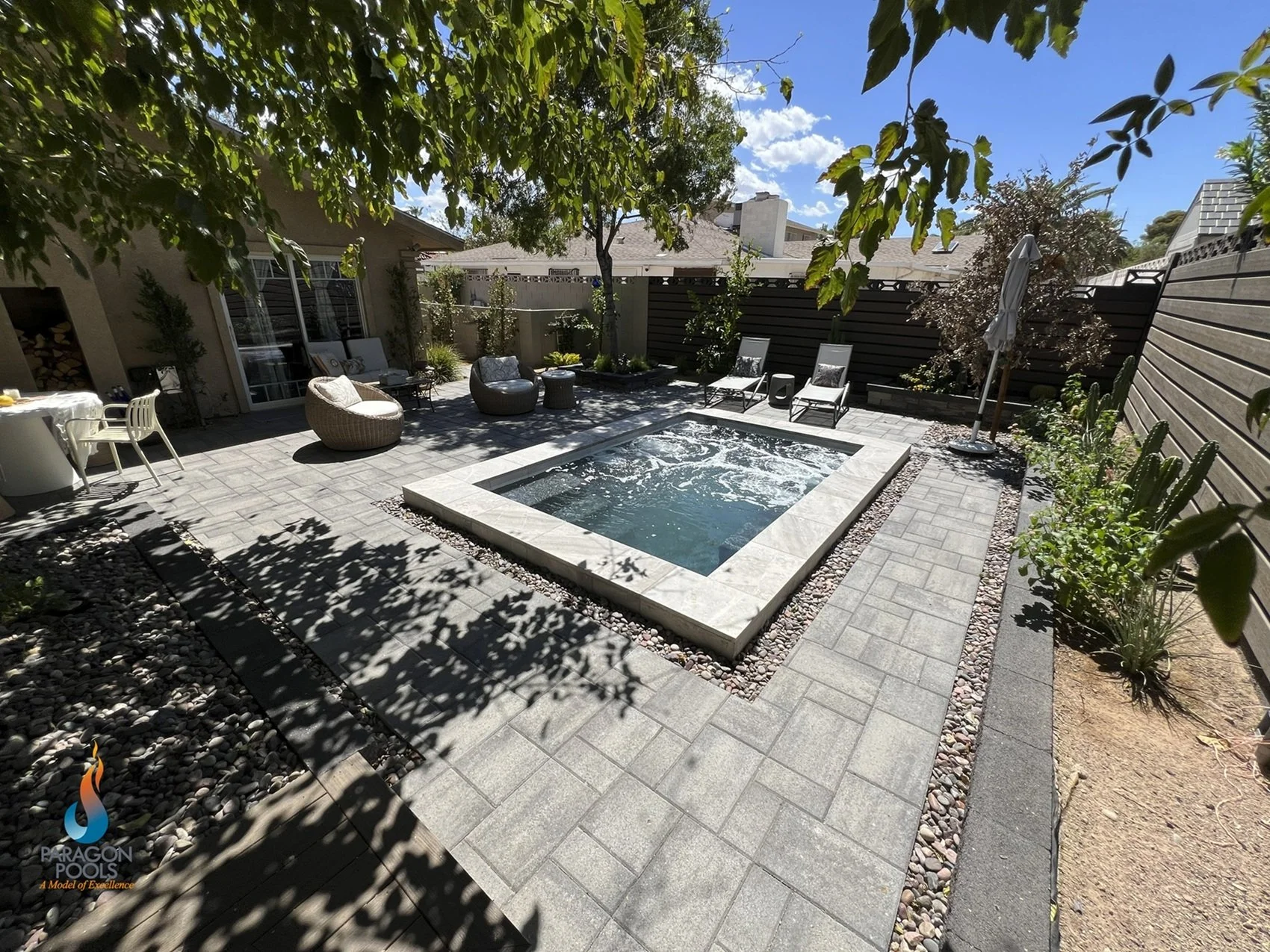 Backyard patio area with a custom spool- combination spa and pool and paver decking.