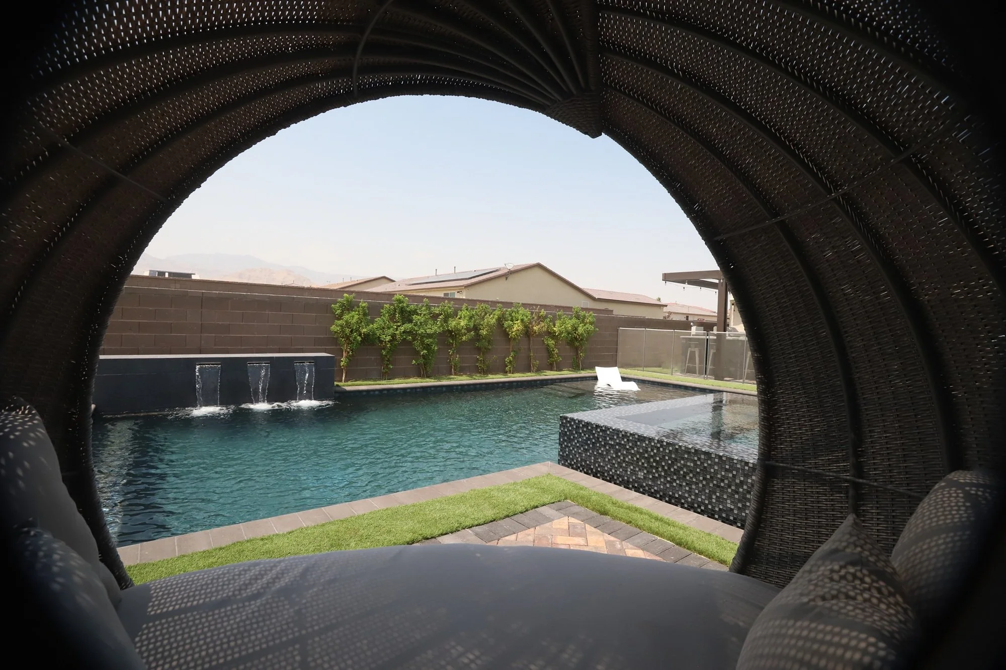 Custom Perimeter overflow spa with a pool featuring an accent wall with three scuppers