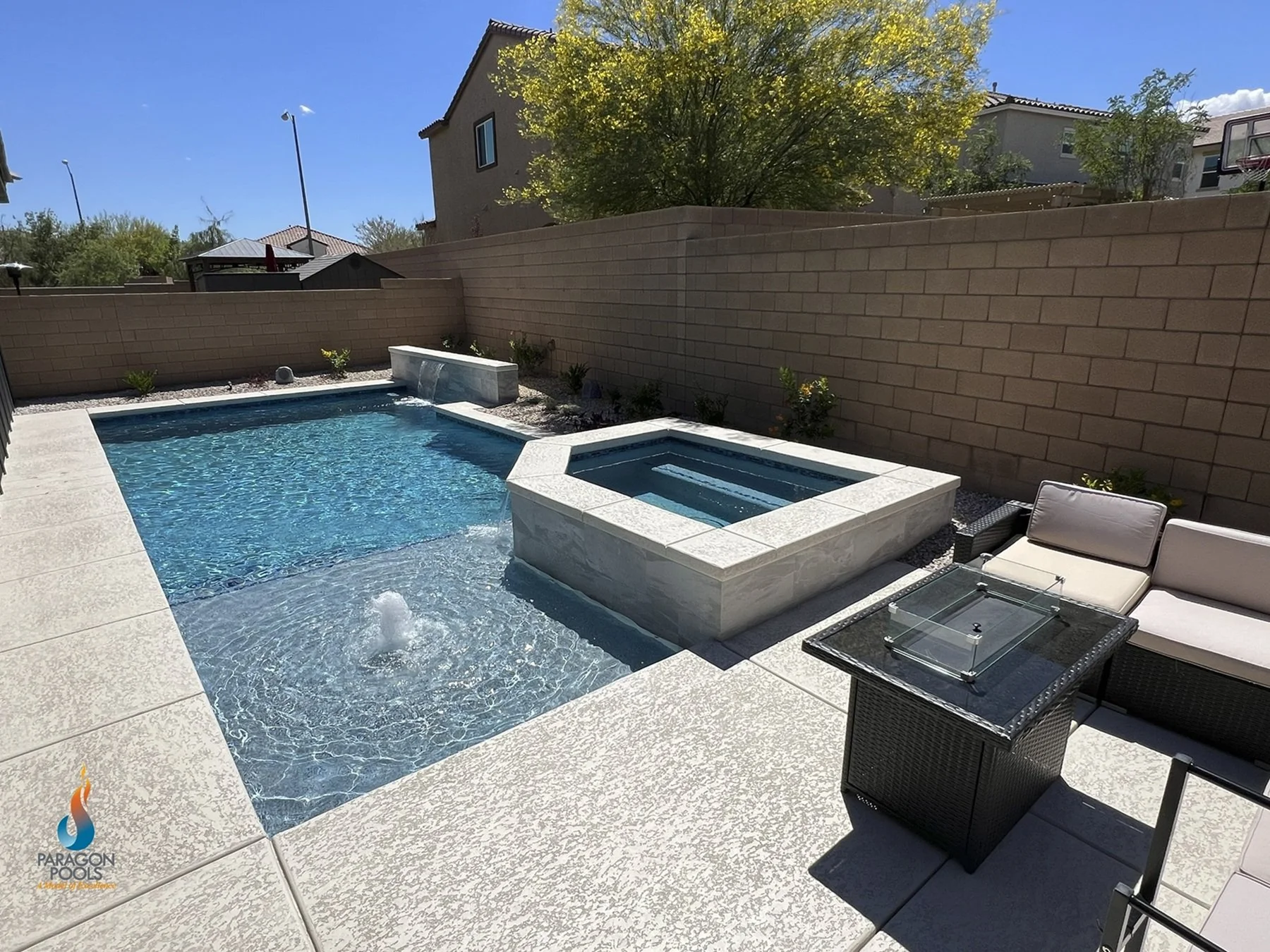 Custom geometric swimming pool with a raised spa, accent wall with a sheer decent and a wet deck with a bubbler in Henderson, NV.