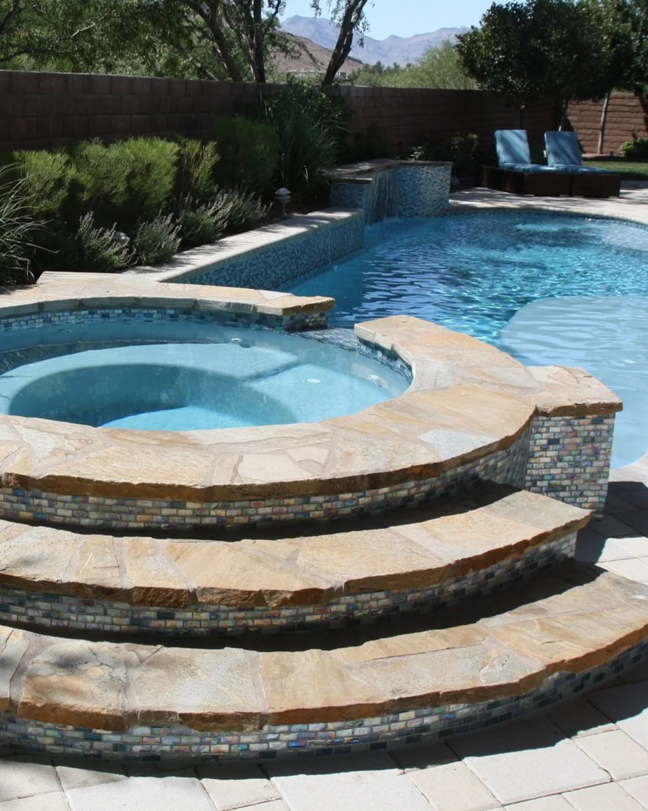 Backyard swimming pool with a raised custom spa, this project was a remodel with  new decking, new tile and new interior finish.