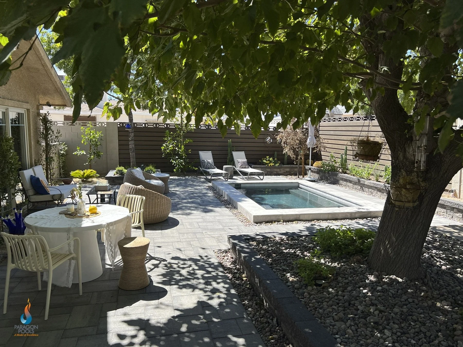 A geometric custom spool with raised coping and paver decking.