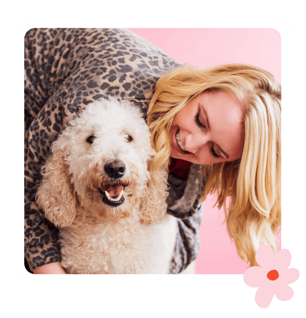 Kate - studio owner of Kurly Creative smiling and cuddling her pet poodle Sienna