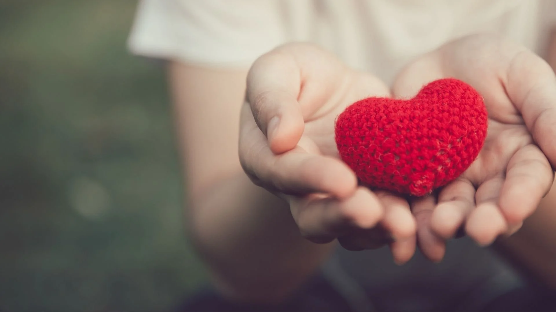 Woman holding crocheted love heart toy