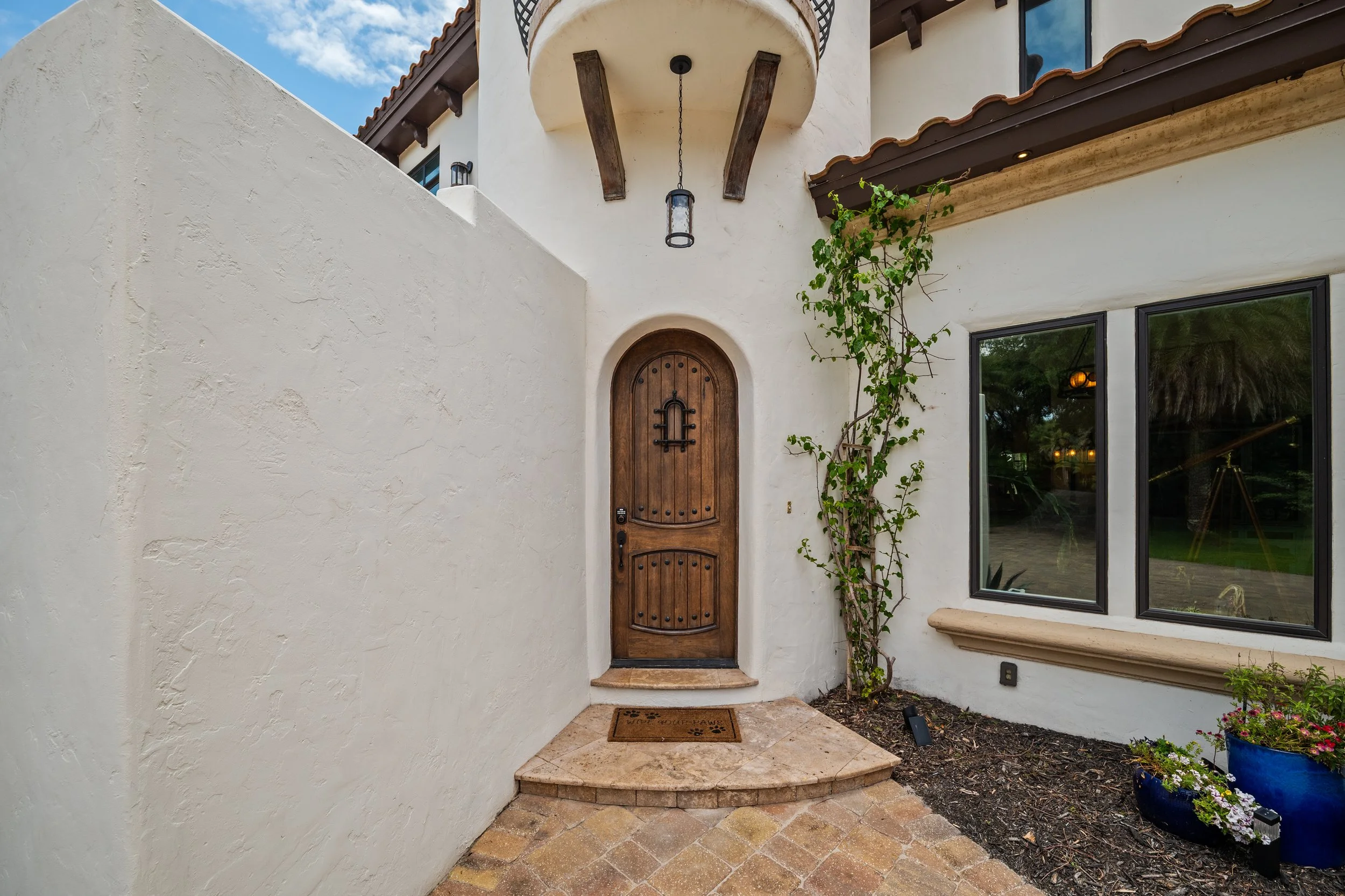 Arched wood entry door on a stucco mansion in Ponte Vedra, FL.