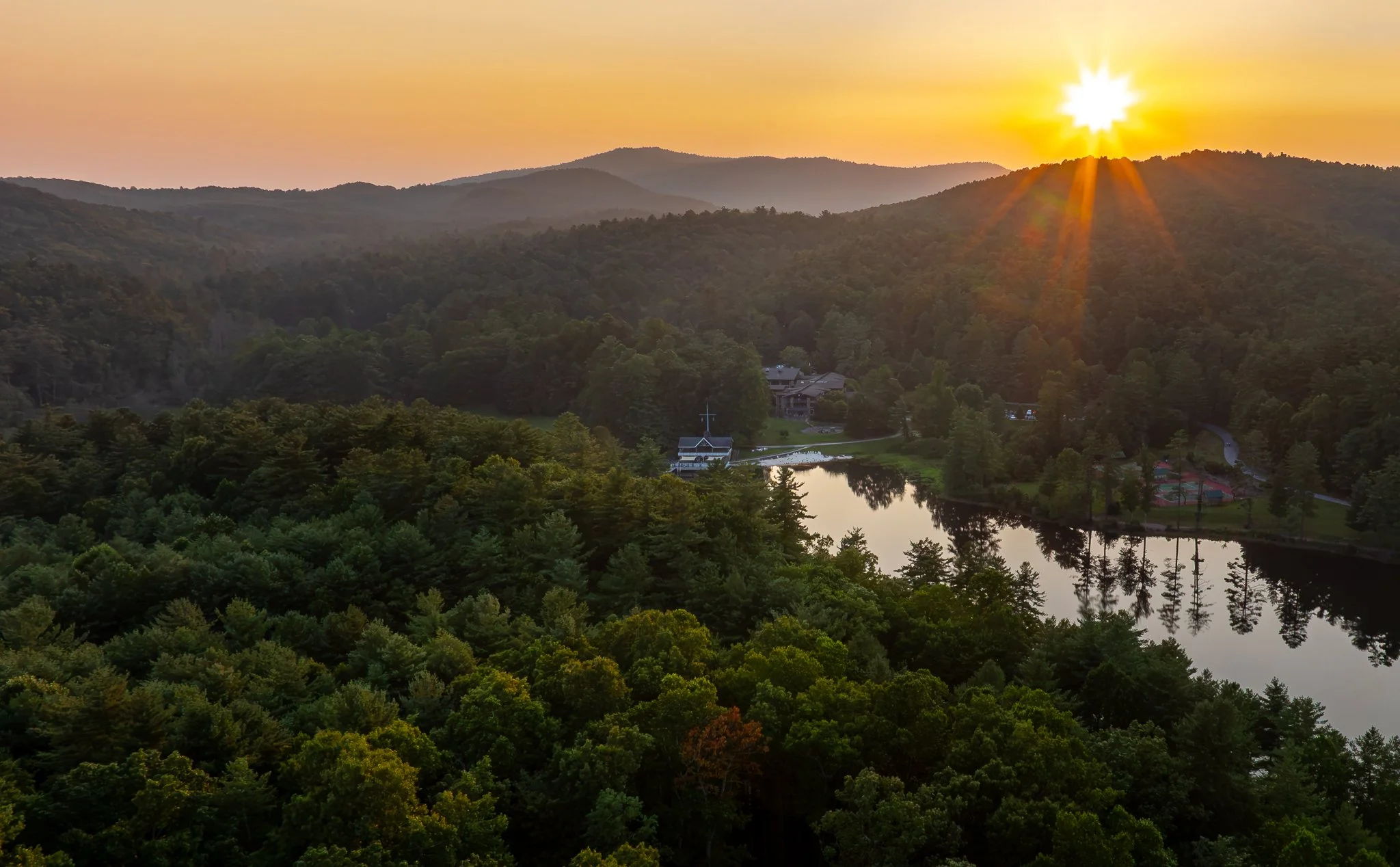 Sunrise over the mountains at Kanuga Conference Center, the lake and lodge tucked into the forested valley below.