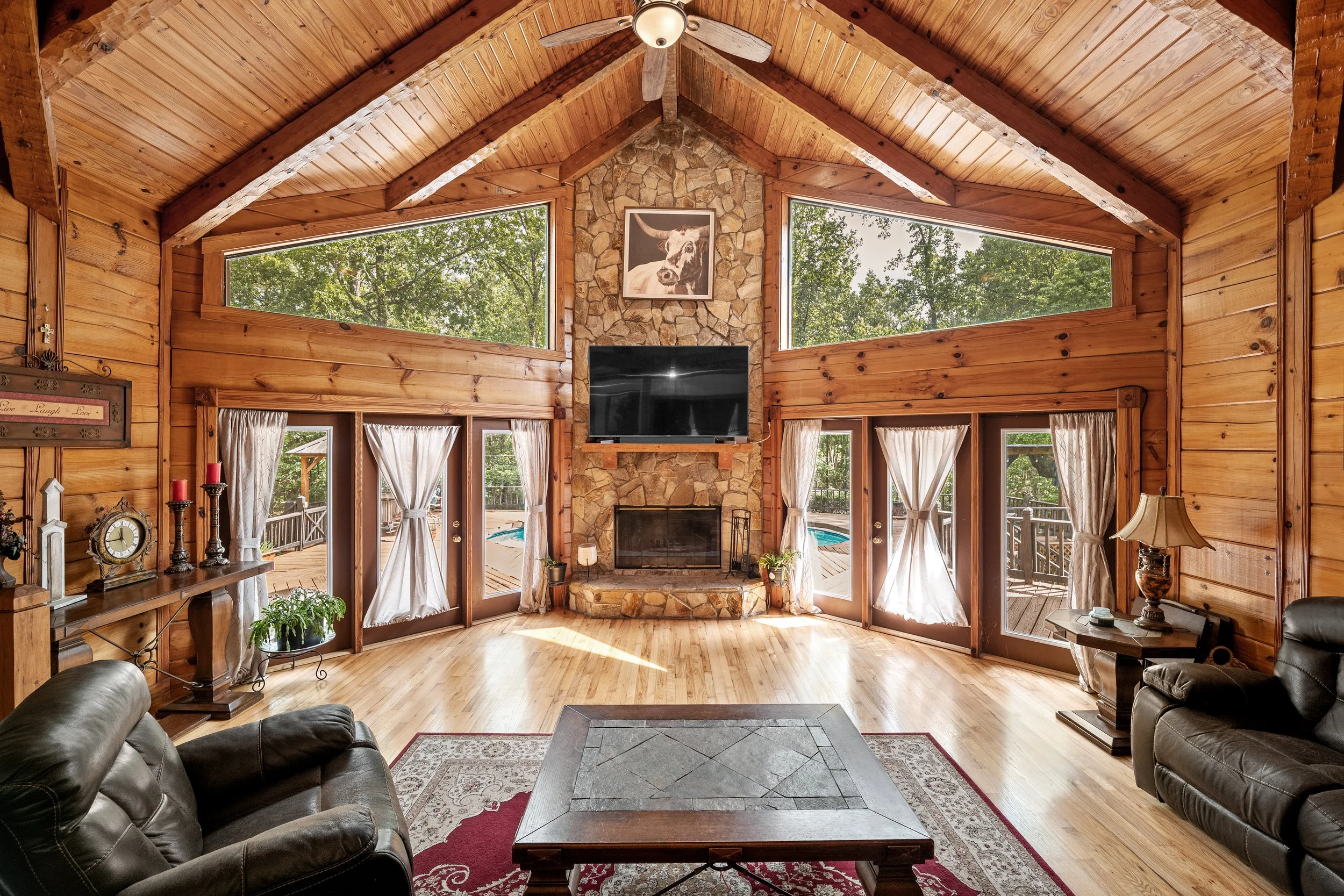 Rustic great room with vaulted wood-beam ceilings and a stone fireplace, Jacksonville, FL.