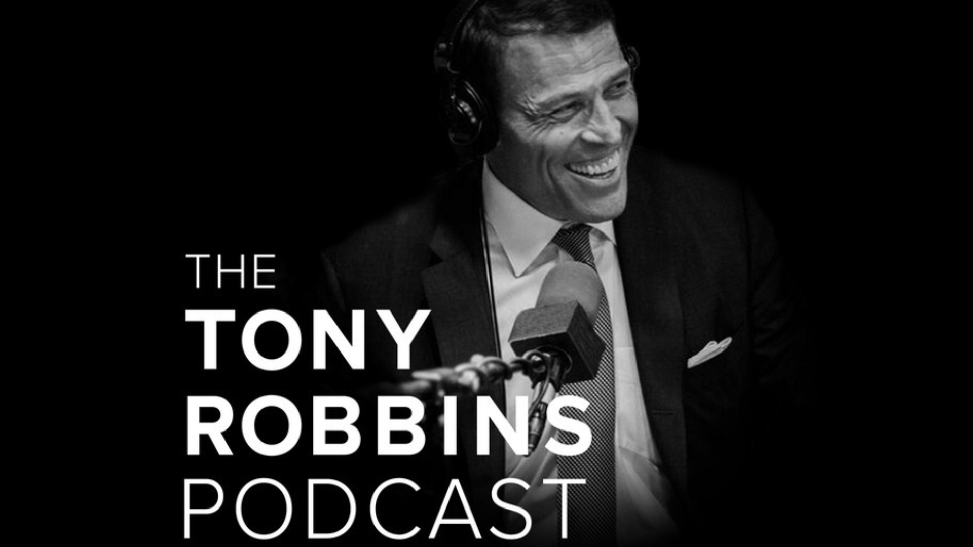 Black and white photo of a smiling man wearing a suit, headphones, and a tie, speaking into a microphone. The text reads 'The Tony Robbins Podcast'.