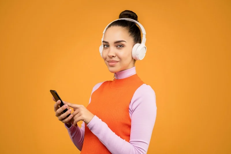 Vrouw In Oranje Roze Shirt Met Lange Mouwen Met Zwarte Smartphone, bron: pexels/Sound On