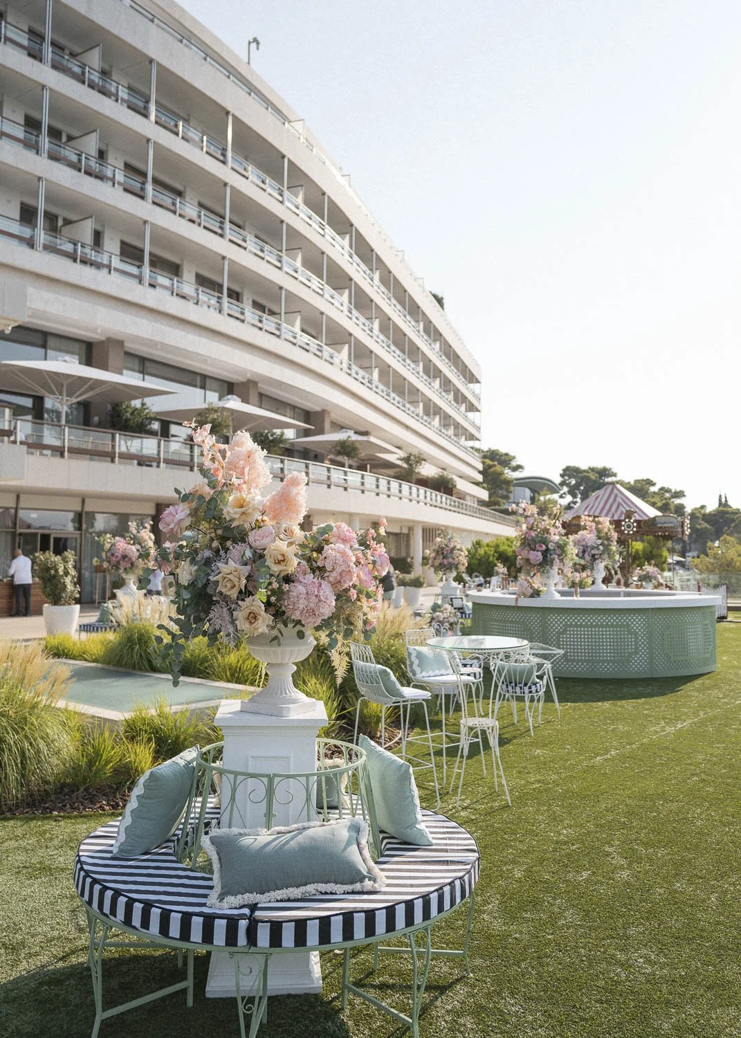 Elegant outdoor seating with floral arrangements at a hotel or event venue.