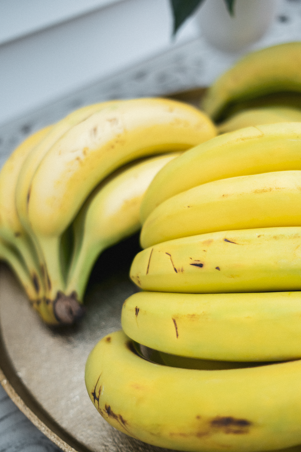 A bunch of ripe yellow bananas arranged on a tray.