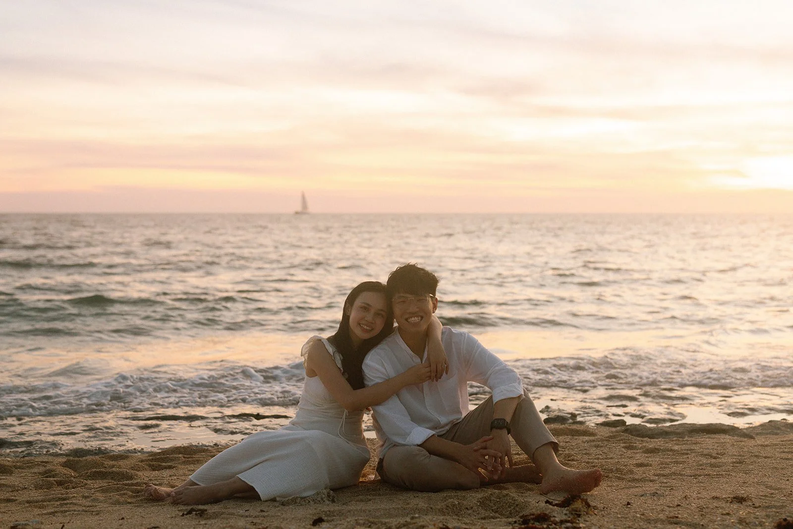 Couple leaning on a wooden lookout fence pointing out to sea at Cape Zanpa, Okinawa