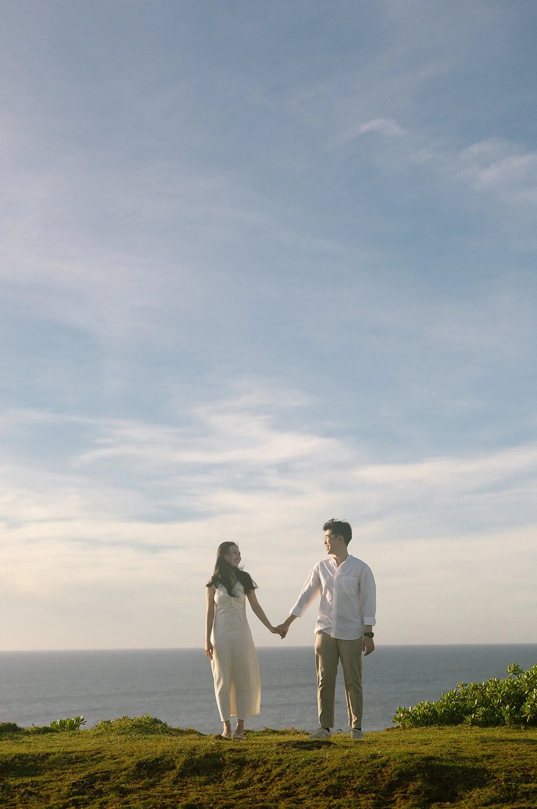 okinawa-proposal-couple-holding-hands-grass-03.jpg
