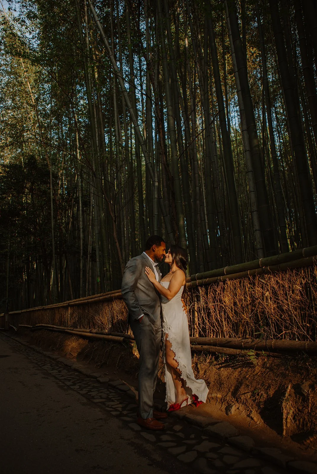 Bride and groom share a close embrace in the golden light of the Arashiyama bamboo grove.