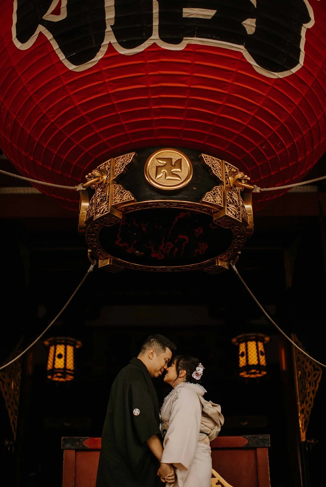 Couple in kimono embracing beneath the giant red lantern at Sensoji Temple in Asakusa, Tokyo