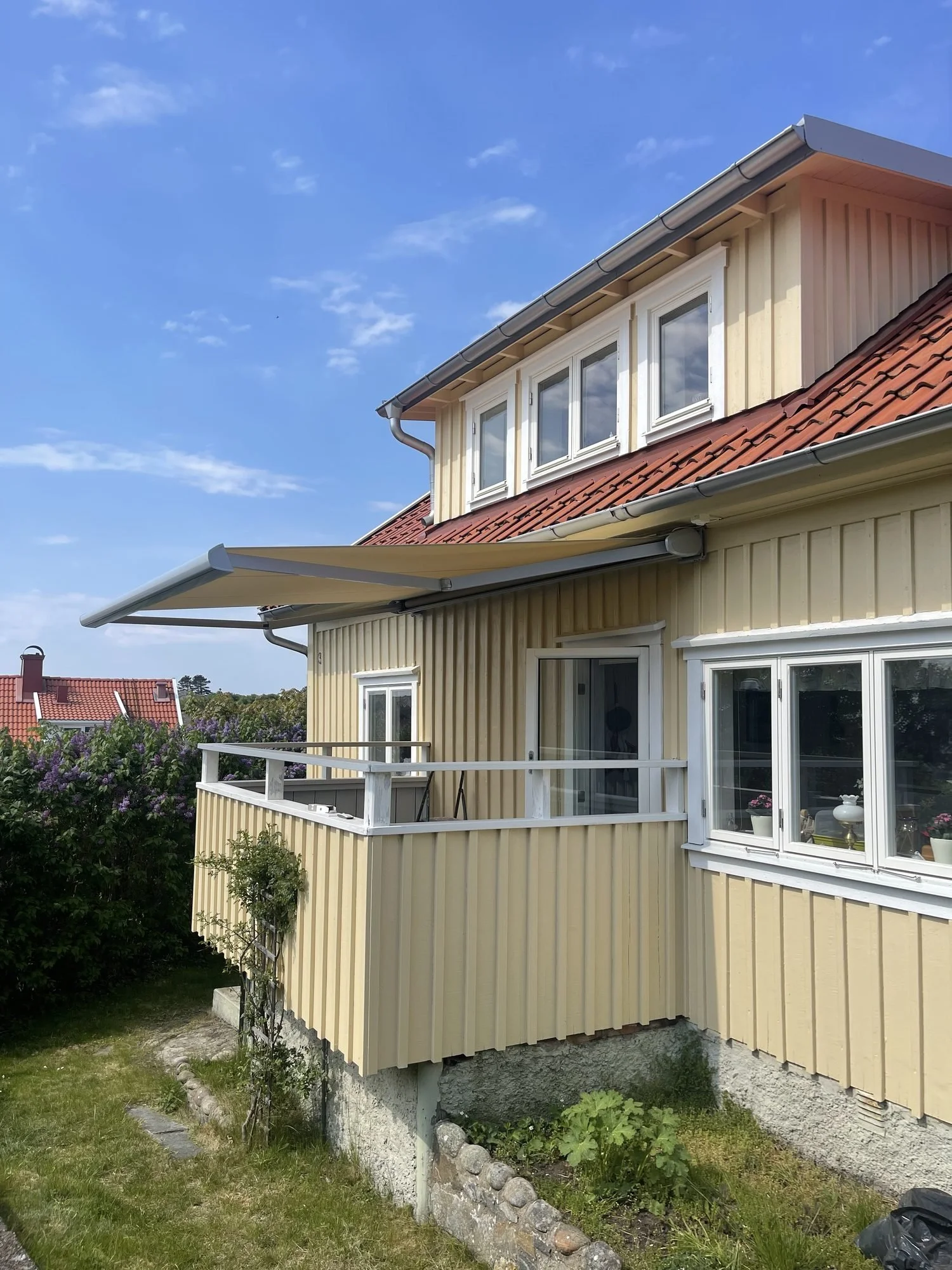 Utfälld terrassmarkis över balkongen på ett hus i Mollösund, Orust