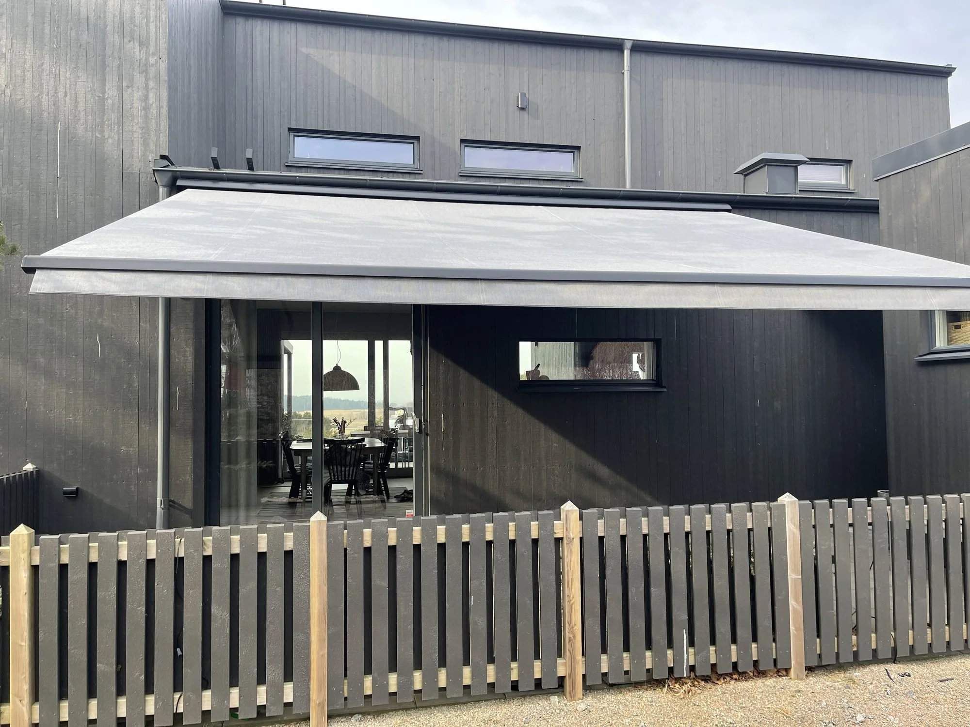 Terrassmarkis över uteplatsen på ett modernt hus i Nolvik, Torslanda