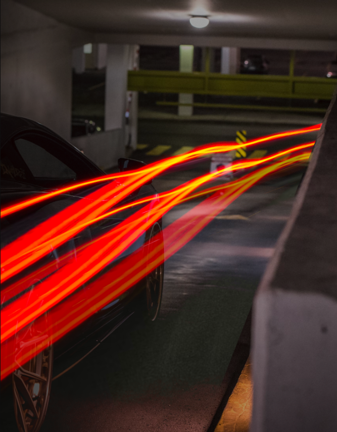 Light trails from a moving vehicle in a parking garage at night.