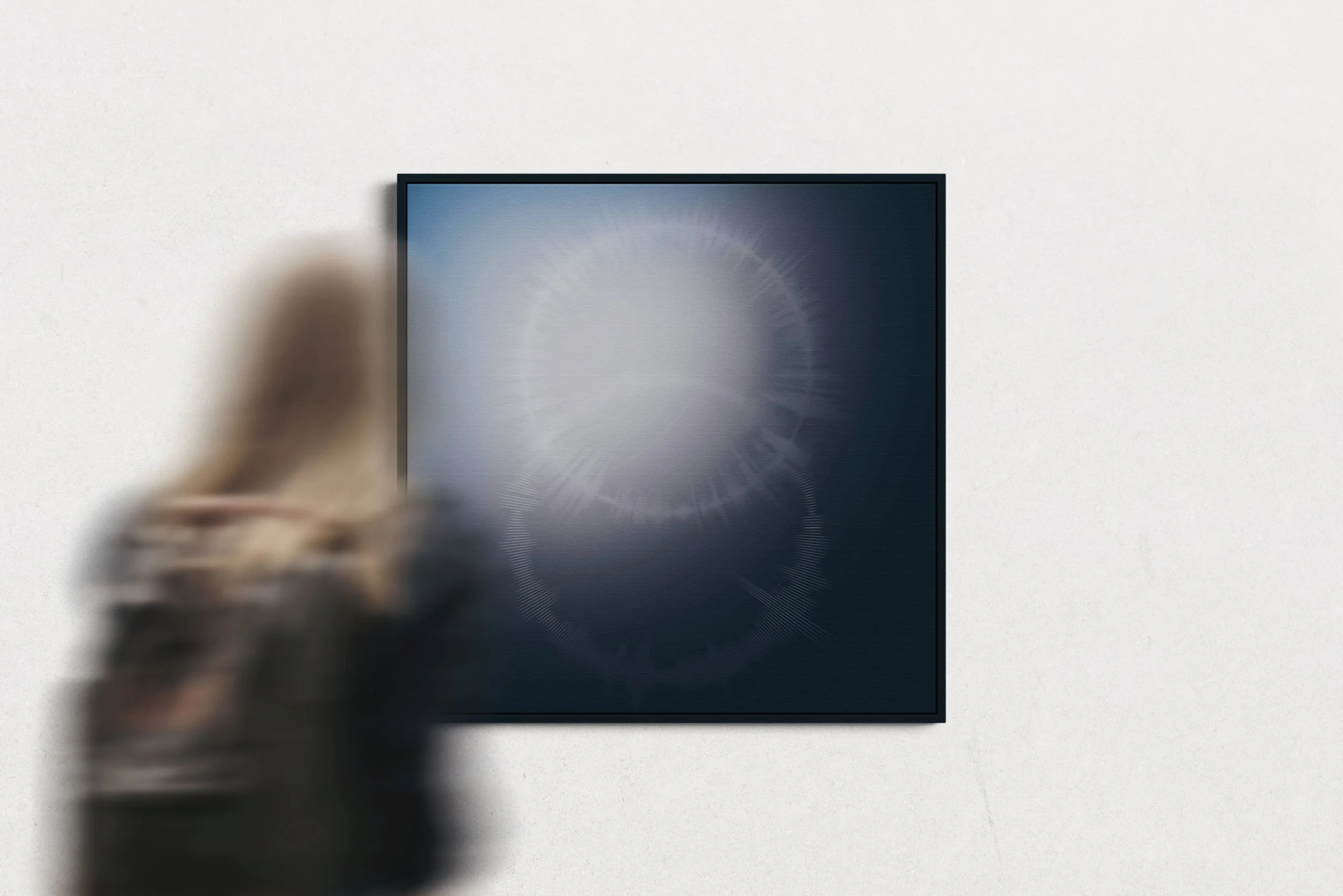 A person with long hair is reaching out to turn on or off a sleek, modern black flat-screen television mounted on a white wall.