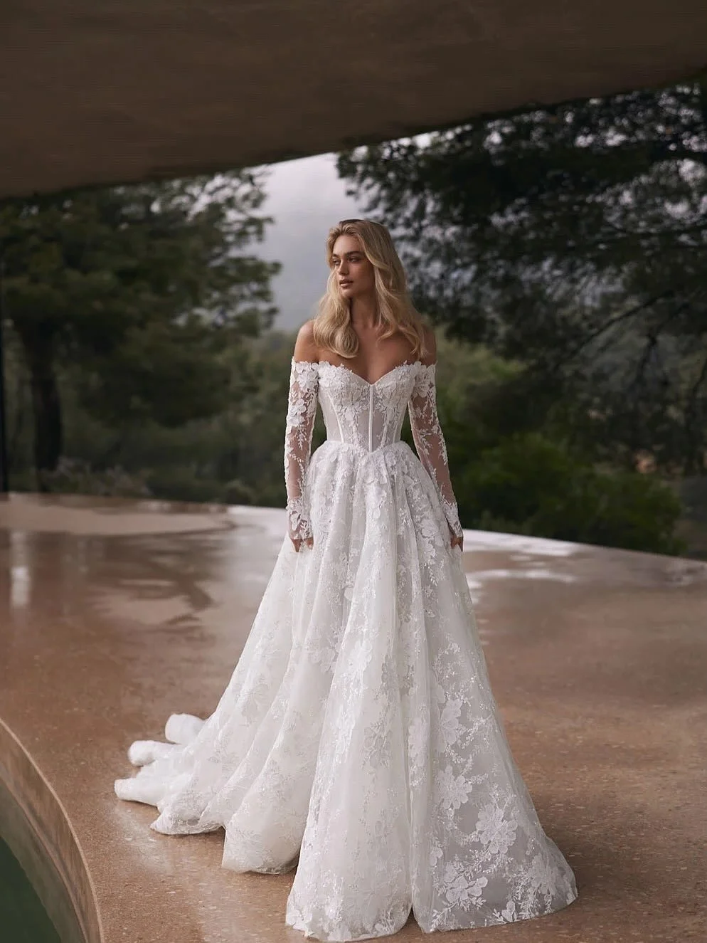 Introducing Hugo @evalendel 

Discover the enchanting A-line gown adorned with delicate floral motifs. Its off-the-shoulder design delicately frames the collarbones, while long, sheer sleeves lend an ethereal quality. The exquisite corset showcases a