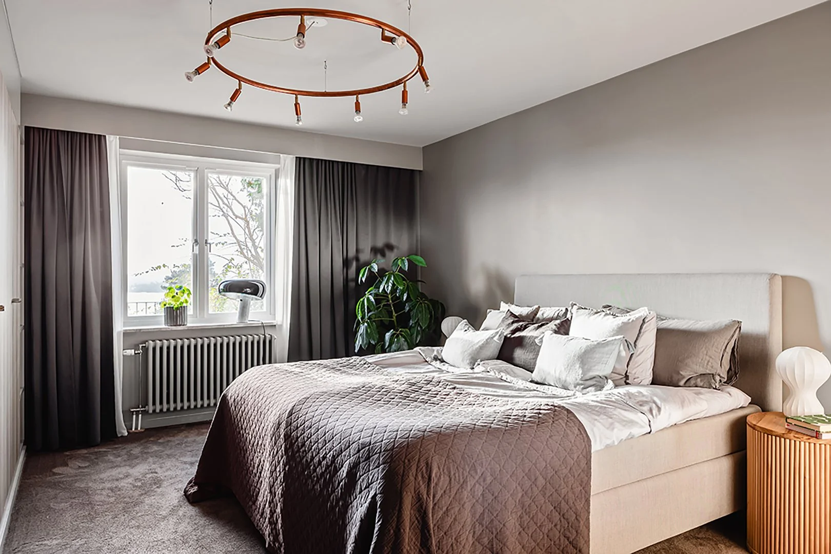 Interiörfoto av ett sovrum med hotellkänsla.