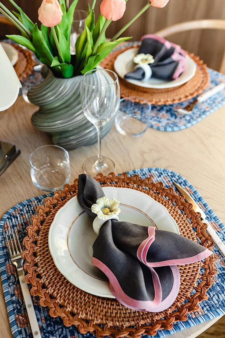 Inredningsfoto av en dukning bestående av vinglas, tyf´gunderlägg, vitt porslin och tygservetter.