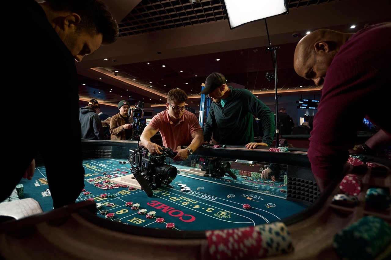Pittsburgh commercial director talks with director of photography at a casino table while filming video on location at Pittsburgh casino.