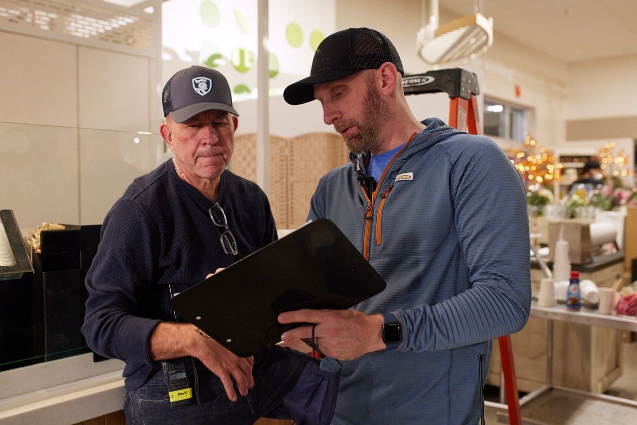 Director and assistant director talking on set during TV commercial production.