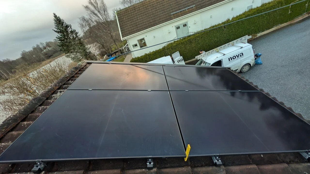 En tak med solpaneler under en molnig himmel.