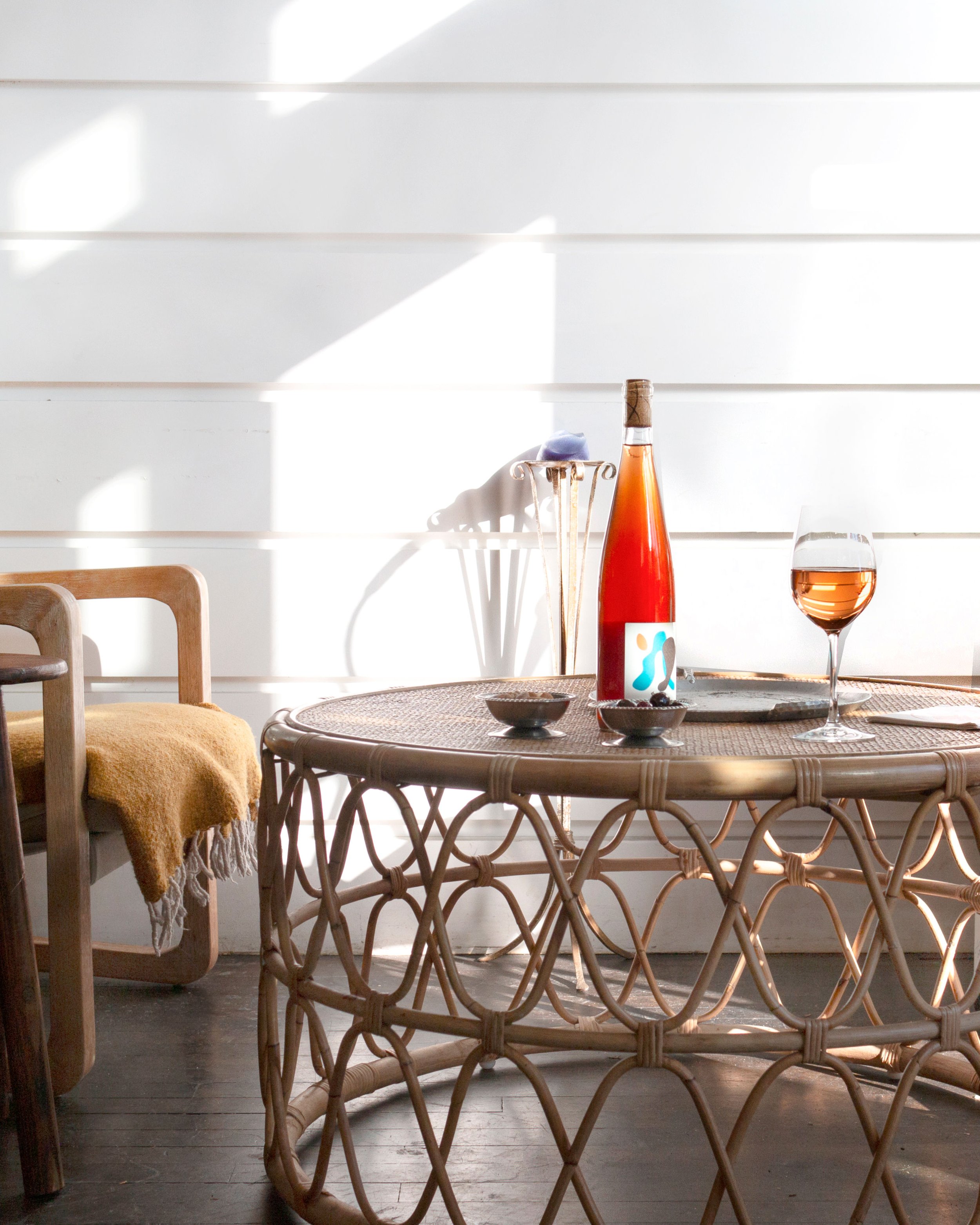  A bottle of wine and a glass of wine sitting on a small table 