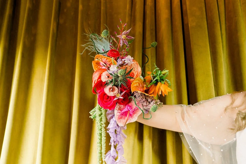  A hand holding out a colorful bouquet of flowers 