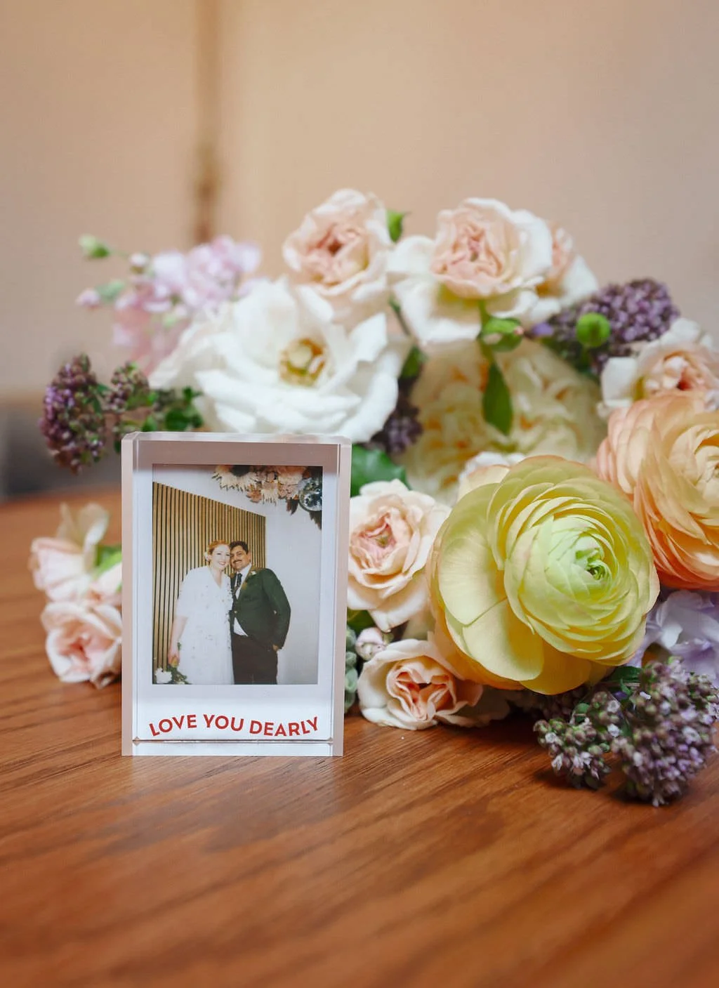  A framed polaroid sitting in front of various flowers  