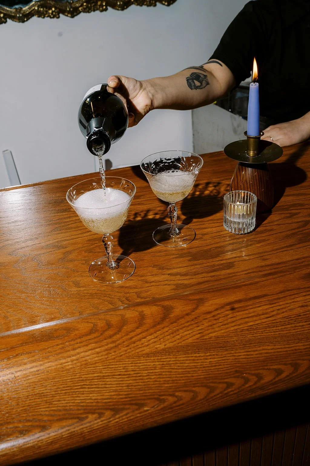  Someone pouring champagne into glasses on a bar 