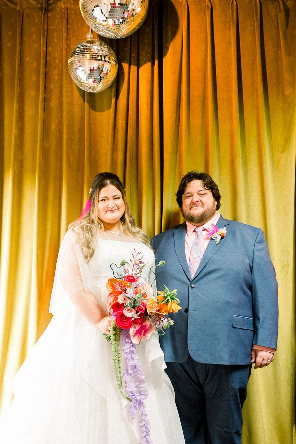  Newlyweds smiling as they stand under disco balls 