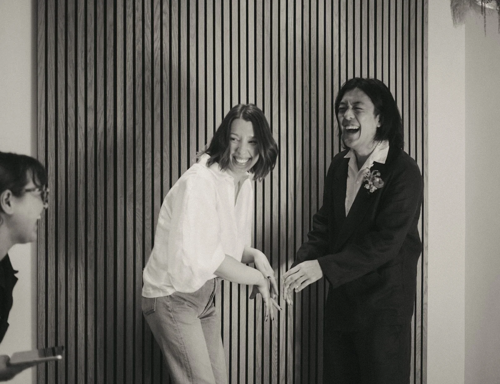  A couple laughing as they hold hands during their wedding ceremony  