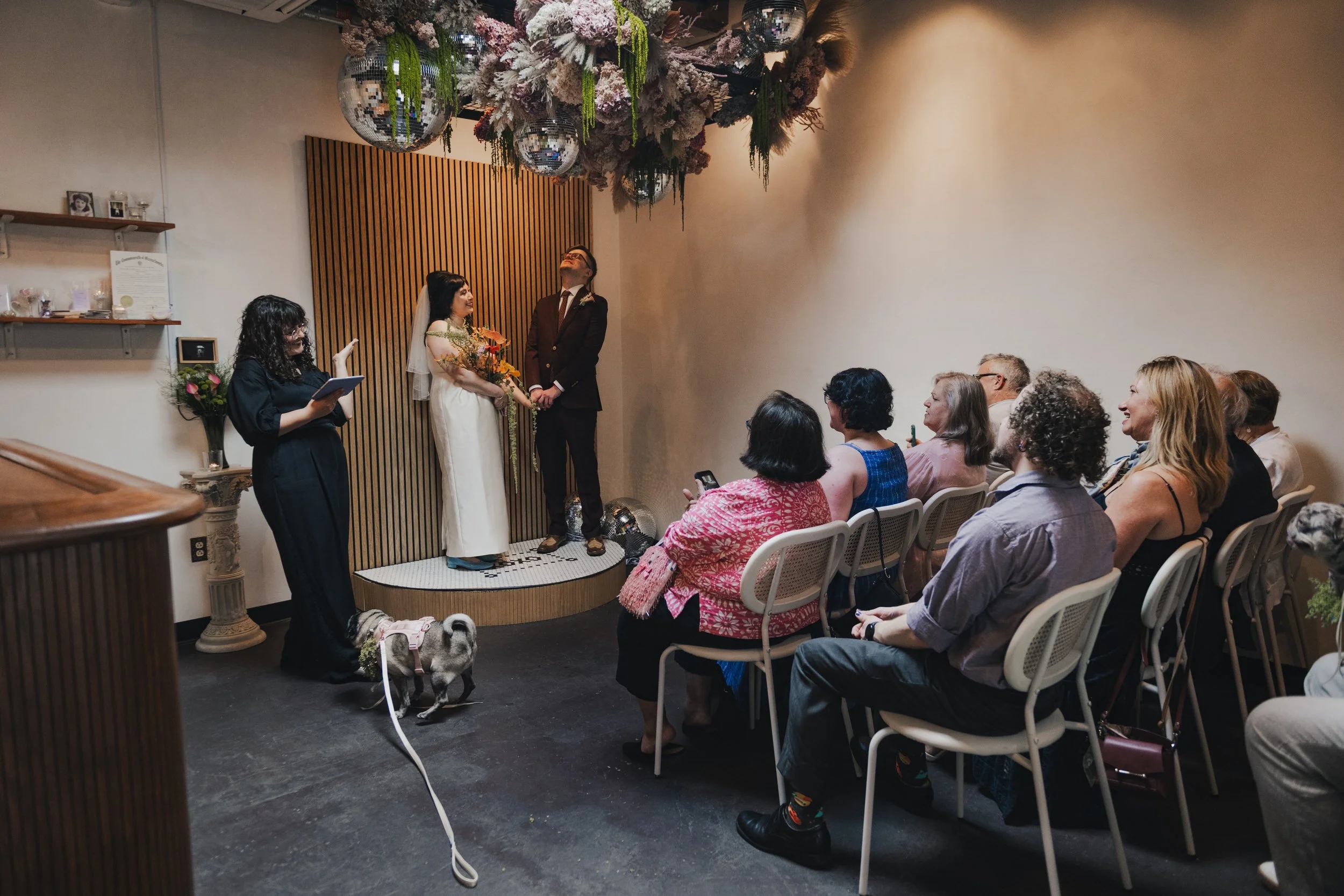 Guests looking on as a couple says their vows during their elopement  