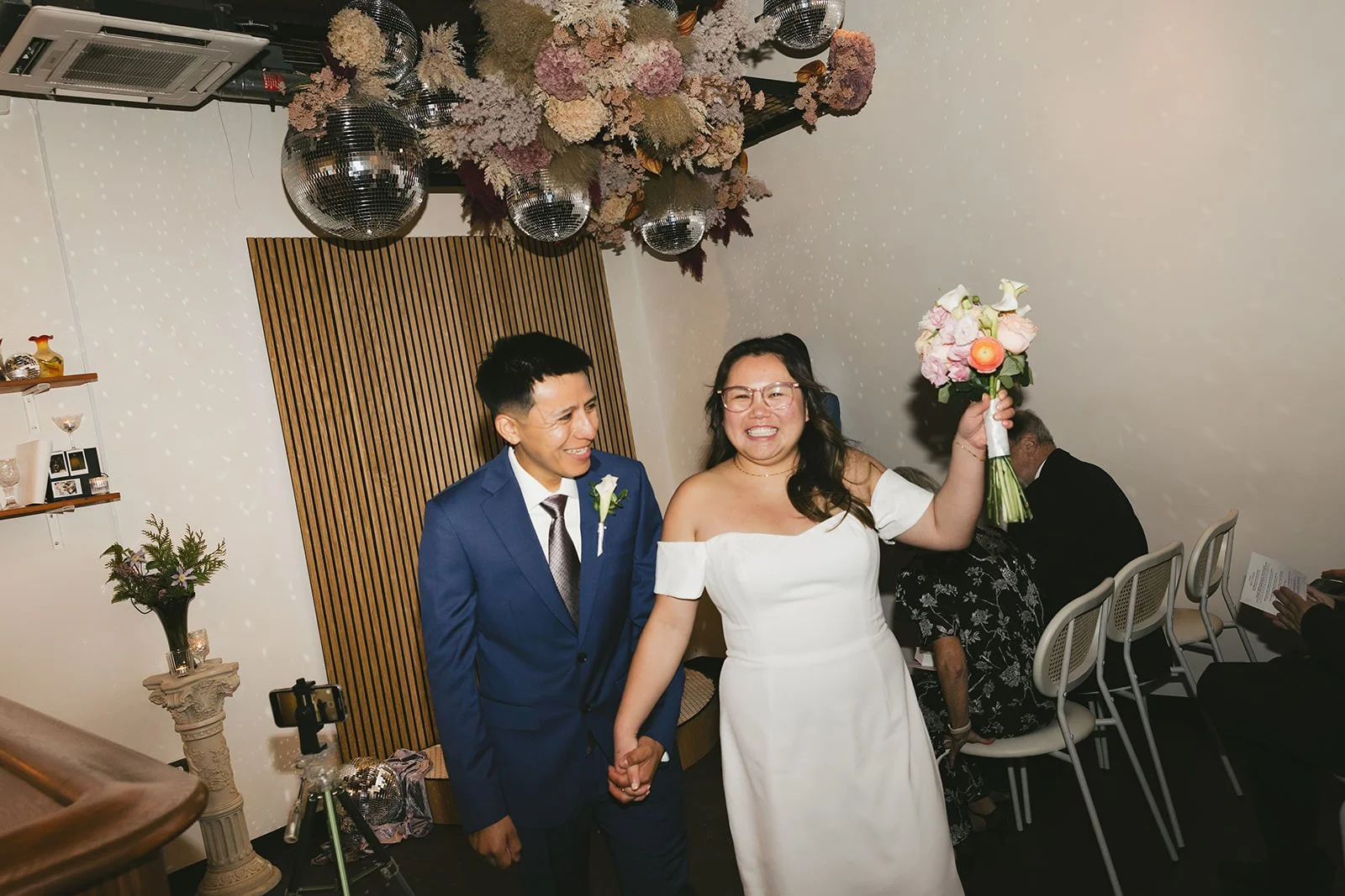 Newlyweds holding hands and smiling as they walk away from their wedding ceremony