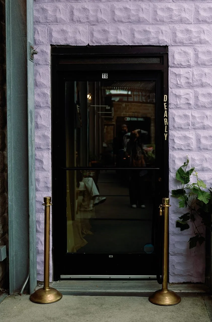  The entrance of Dearly Studio with purple brick surrounding the door 