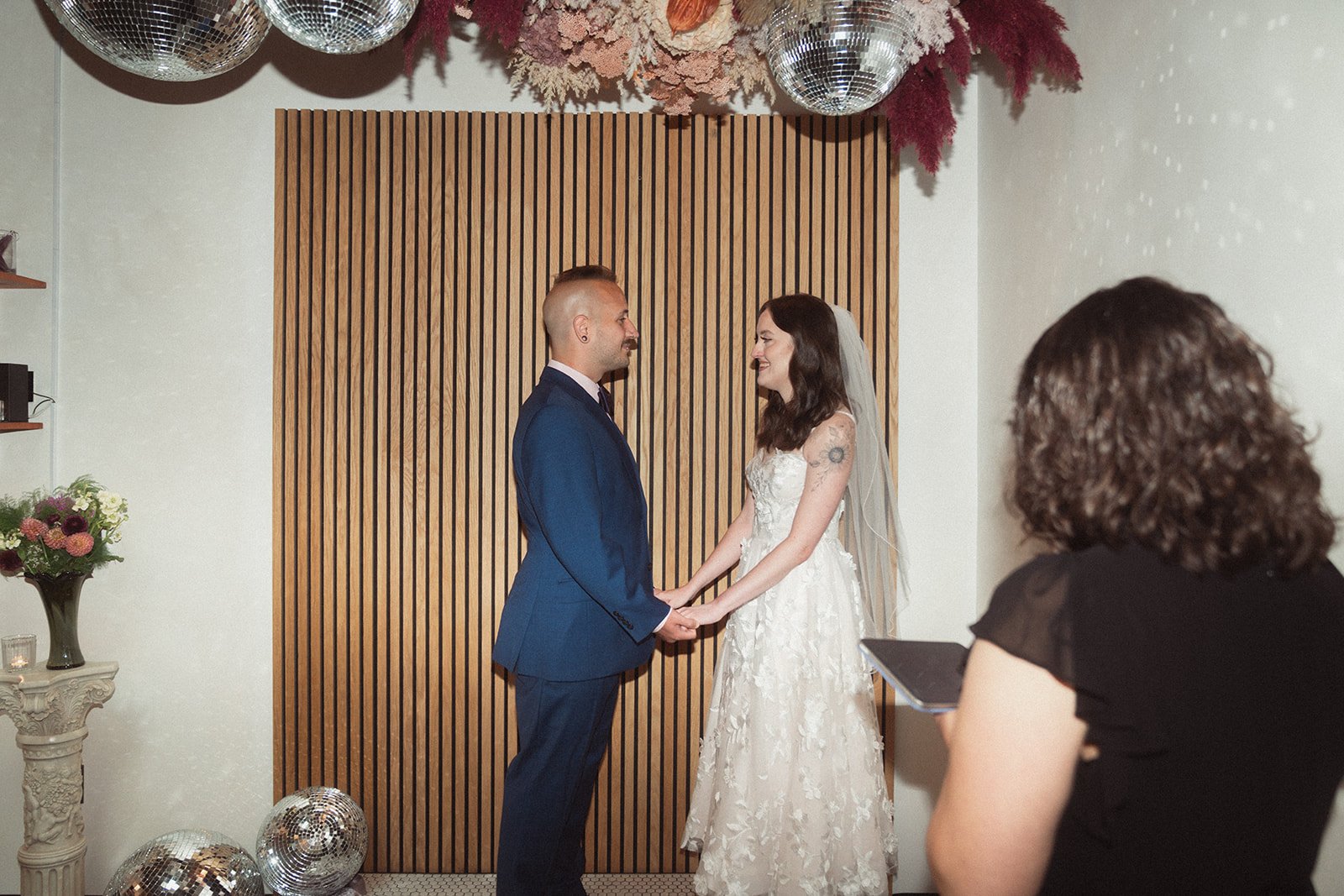 Two people standing at a wedding altar space being married. 