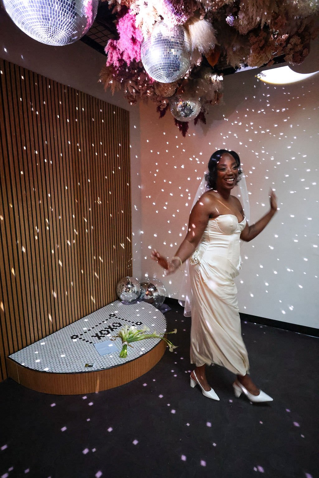 A person in a wedding dress dancing under disco lights