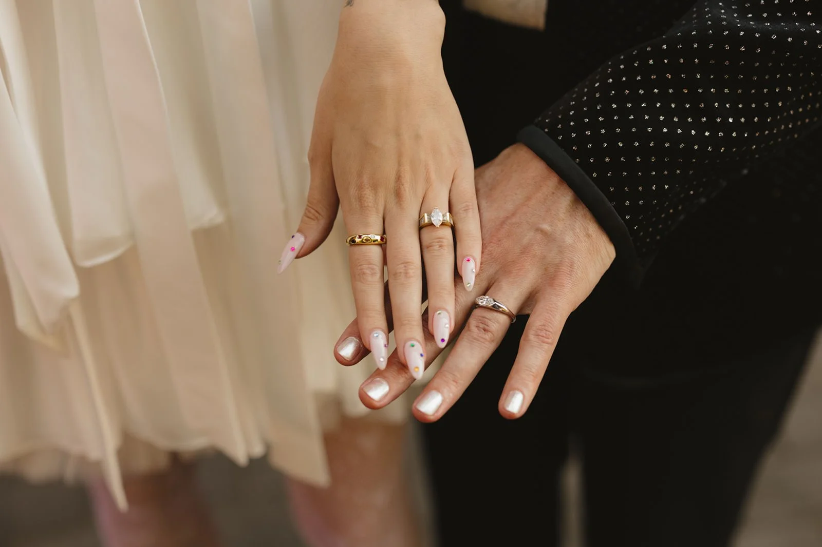 Two hands stacked on top of each other showing off wedding rings