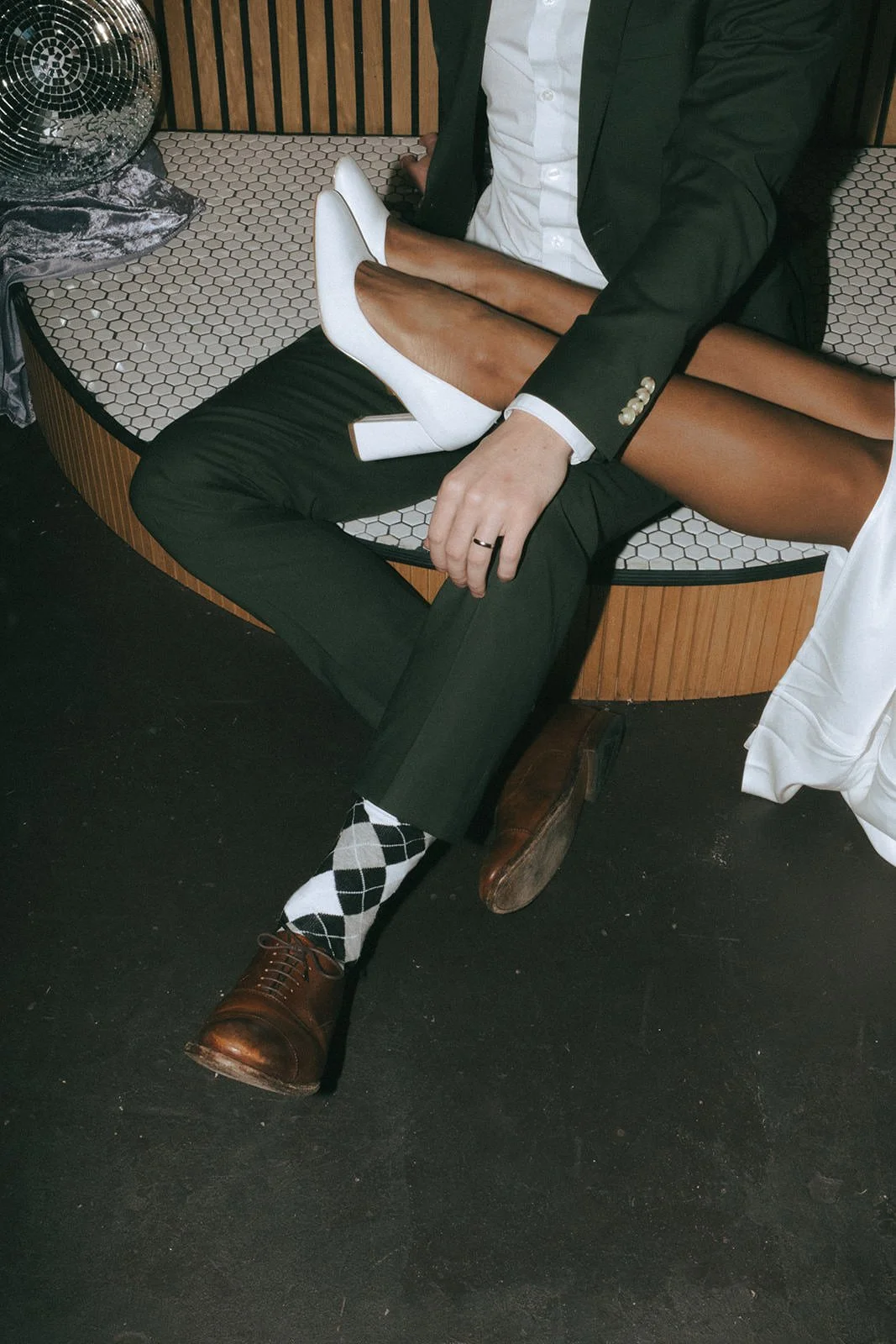 A close up of a newlywed resting their feet over their partner's lap