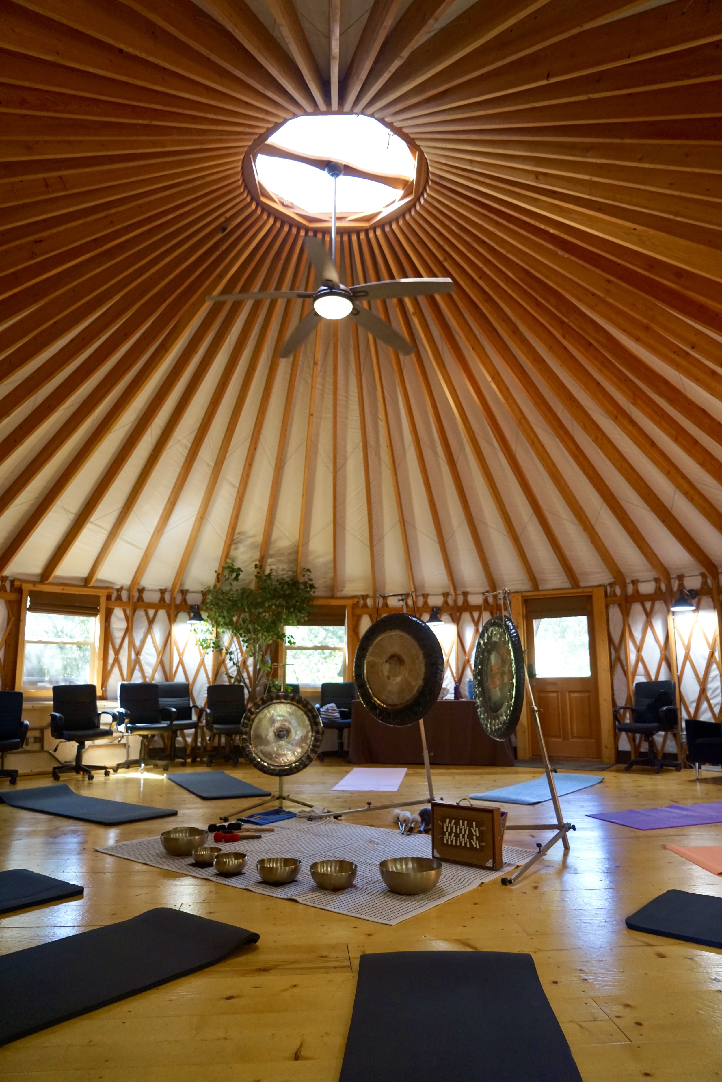 ONDO Holistic somatic sound bath set up for a company retreat in a yurt, with sound bowls and large meditation gongs.
