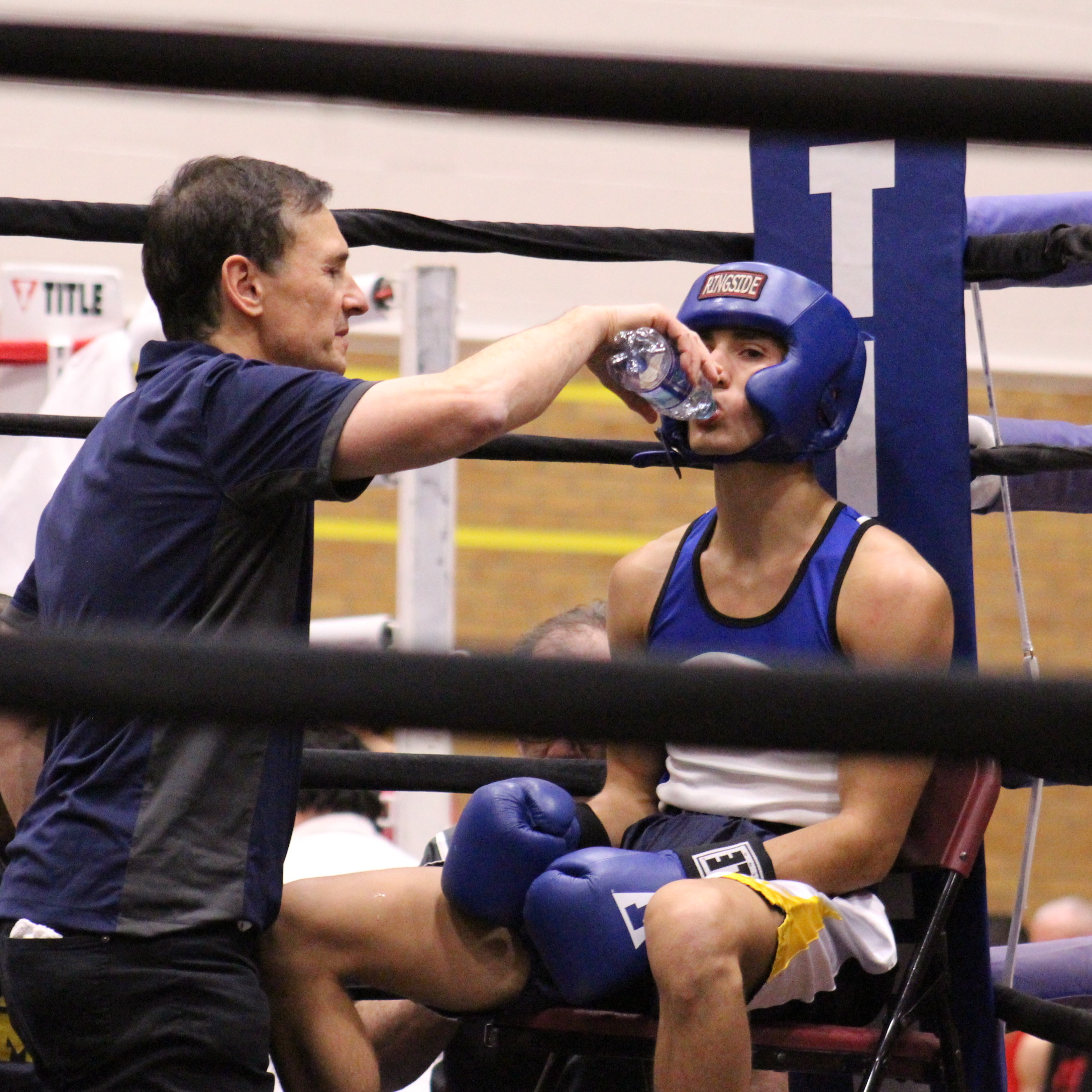 amateur boxer sitting in corner with coach