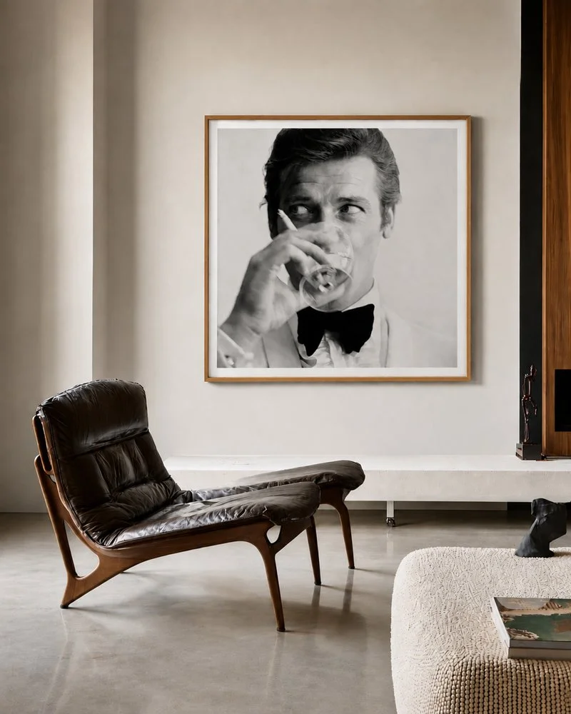 A large black-and-white portrait of a man in a tuxedo drinking from a glass, displayed on a gallery wall.