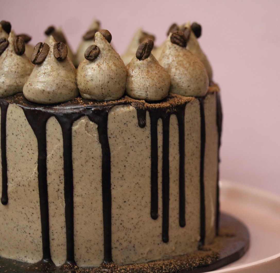 Gluten-free, dairy-free, refined sugar-free chocolate coffee cake with rich chocolate layers, a subtle coffee flavour, and a smooth coffee frosting, garnished with coffee beans