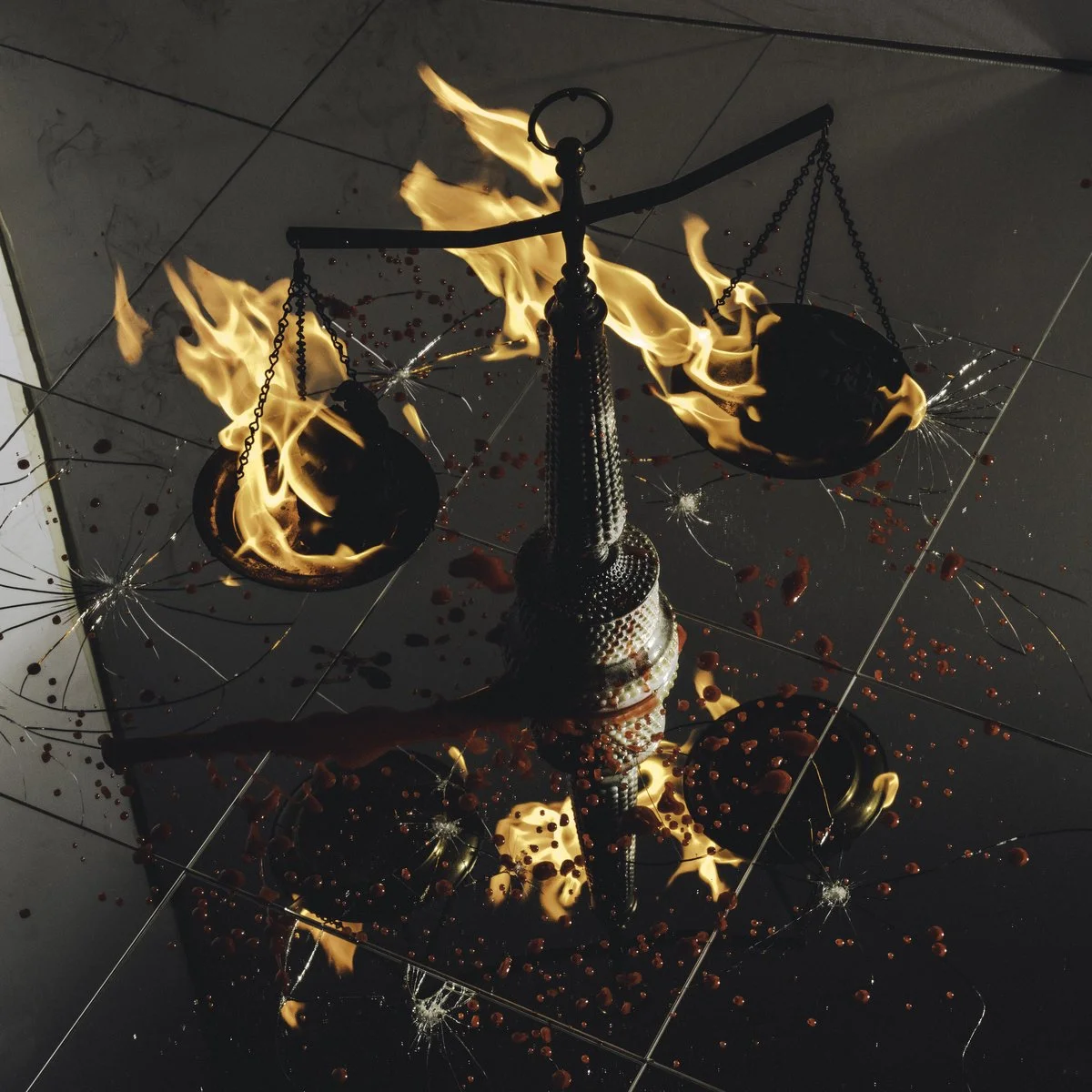 A scale on a reflective surface that appears to be on fire, with spilled red liquid and shattered glass around it.
